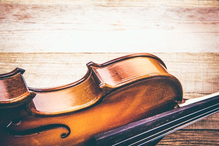 Ancient violin on a table of rough unplaned boardsの写真素材