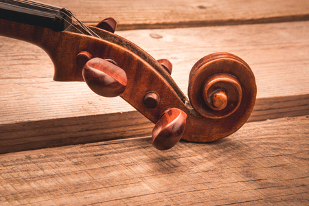 Ancient violin on the background of old unplaned boardsの写真素材