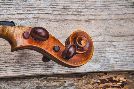 Ancient violin on the background of old unplaned boardsの写真素材
