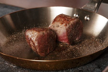 grilled beef steak with spieses on frying pan in a restaurantの写真素材