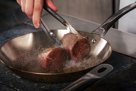 grilled beef steak with spieses on frying pan in a restaurantの写真素材