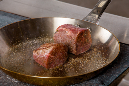 grilled beef steak with spieses on frying pan in a restaurantの写真素材