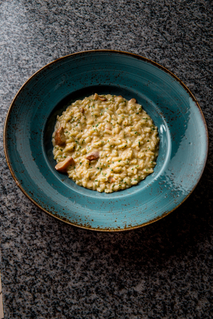 classical italian risotto with mushrooms in a green plateの写真素材
