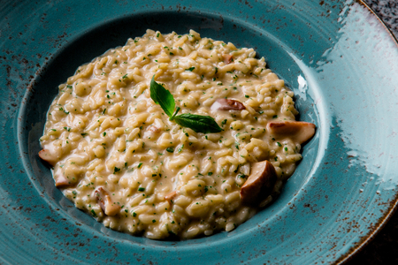 classical italian risotto with mushrooms in a green plateの写真素材