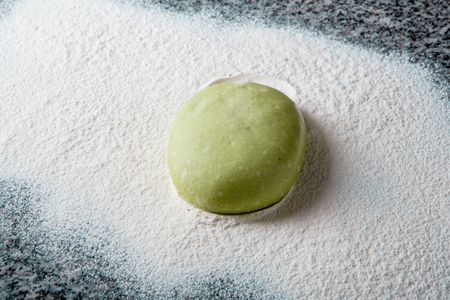 piece of dough for pizza in flour on a marble slabの写真素材