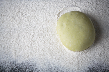 piece of dough for pizza in flour on a marble slabの写真素材