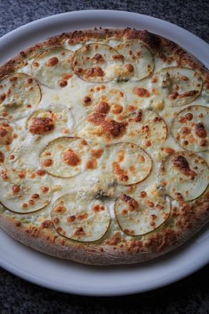 Italian national food, pizza with pear and gargantilla on a white plateの写真素材