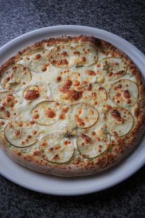 Italian national food, pizza with pear and gargantilla on a white plateの写真素材