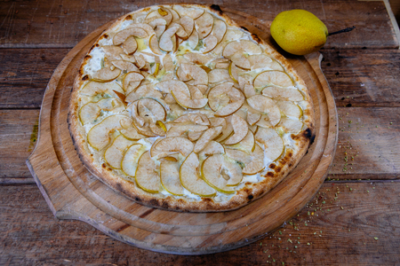 traditional italian pizza with pear and gargantzolla on a wooden boardの写真素材