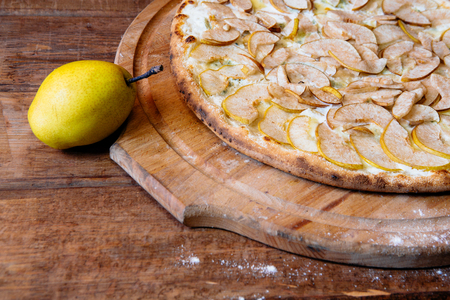 traditional italian pizza with pear and gargantzolla on a wooden boardの写真素材