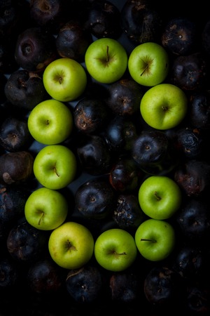 Fresh green apple alphabet letter on a background of rotten applesの写真素材