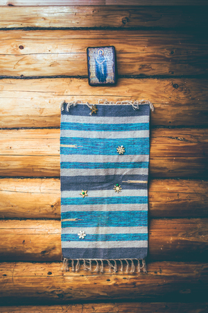 blue homespun rug on the log wall in old wooden houseの写真素材