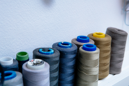 spools of colored thread in the workshop on the shelfの写真素材