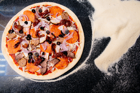 Salami pizza on the tableの写真素材