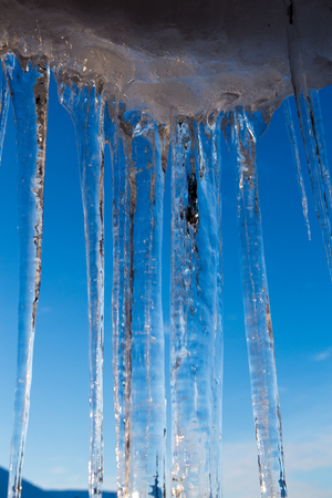 A lot of icicles over blue skyの写真素材