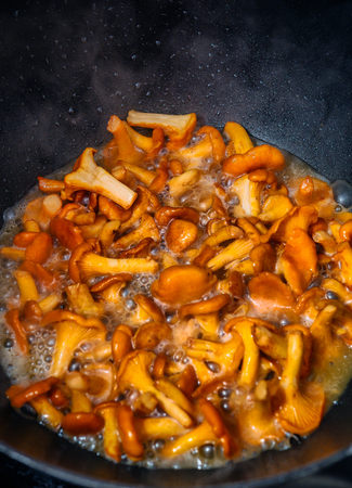 Fried chanterelle mushrooms in a cast iron panの写真素材