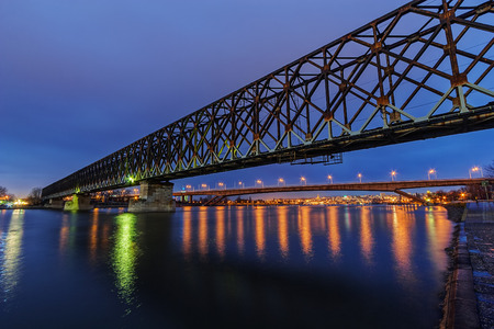 Steel bridge across river at nightの写真素材