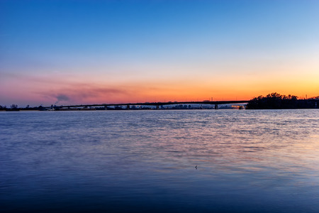 Steel bridge across river at nightの写真素材