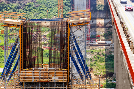high altitude concrete bridge construction with crane and frameworkの写真素材