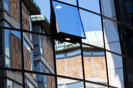reflection of stone facade on modern glass facade