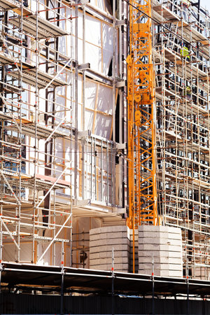 building under construction with scaffolding and crane