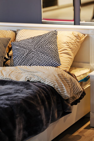 Detail of classic furniture bed with pillows in bedroom.
