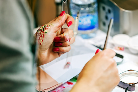 Young beautiful woman in a nail salon receiving a manicure by a professional beauticianの写真素材