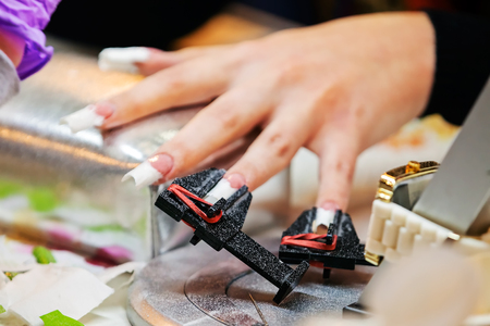Young beautiful woman in a nail salon receiving a manicure by a professional beauticianの写真素材