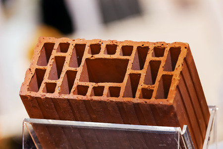 Detail of orange hollow clay block on a stand at construction fair の写真素材
