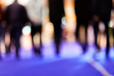 Blurred of group of businessmen walking on job fair; note shallow depth of fieldの写真素材