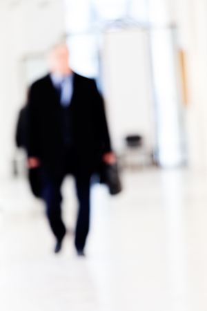 Silhouette of a businessman walking in the corridor, blurred 100%の写真素材
