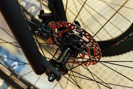 Closeup of bicycle front wheel and chrome shaft; note shallow depth of fieldの写真素材