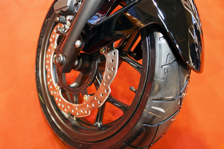 Closeup of quality steel motorcycle wheel with new tyre; note shallow depth of fieldの写真素材