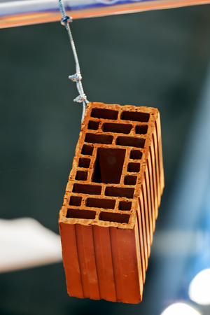 Detail of orange hollow clay block on a stand at construction fairの写真素材