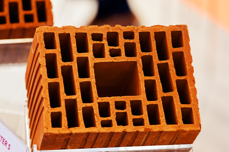 Detail of orange hollow clay block on a stand at construction fairの写真素材