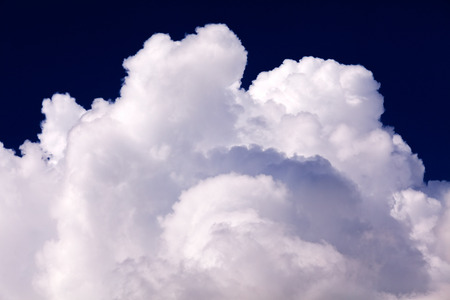 Big white fluffy cloud in deep blue skyの写真素材