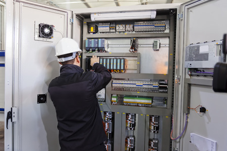 Man worker checking advanced industrial control panelの写真素材
