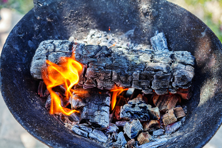 Wood burning with flames, ash and smoke in a barbecueの写真素材