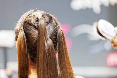 making coiffure with help of hair straightener, note shallow depth of fieldの写真素材