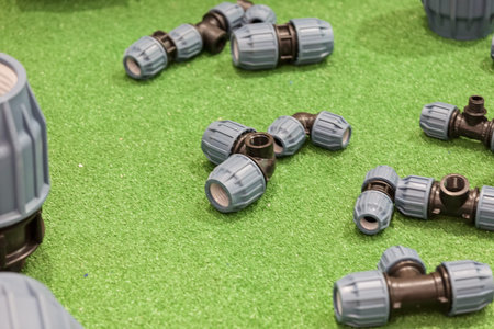 Various types of connector for water pipes on the green background, note shallow depth of field