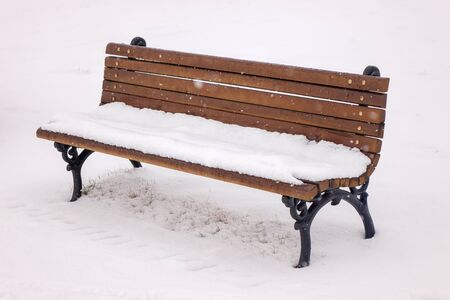 Bench in the park under the snowの写真素材