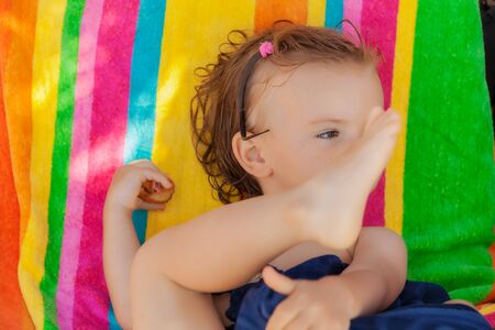 baby eating a donut on the beach, note shallow depth of fieldの写真素材