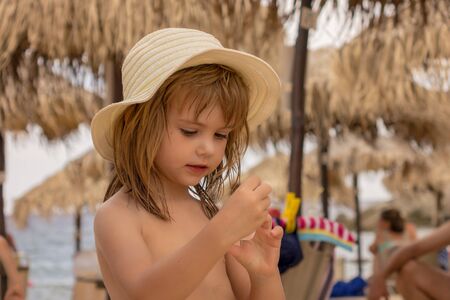 a little girl with a hat on the beachの写真素材