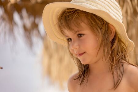 a little girl with a hat on the beachの写真素材