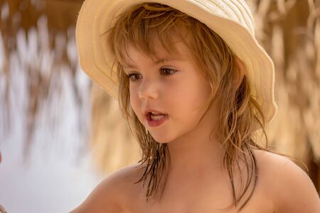 a little girl with a hat on the beachの写真素材