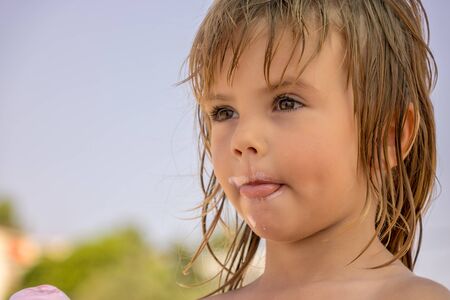 face of a little girl dirty with ice creamの写真素材