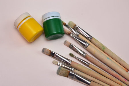 Multicolor watercolor paints and brushes on the surface of the material