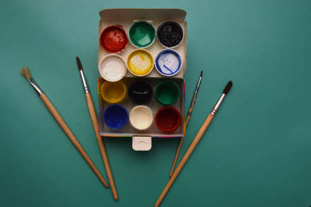 Multicolor watercolor paints and brushes on the surface of the materialの写真素材
