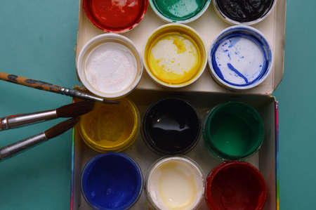 Multicolor watercolor paints and brushes on the surface of the materialの写真素材