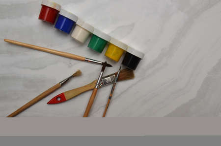 Multicolor watercolor paints and brushes on the surface of the materialの写真素材